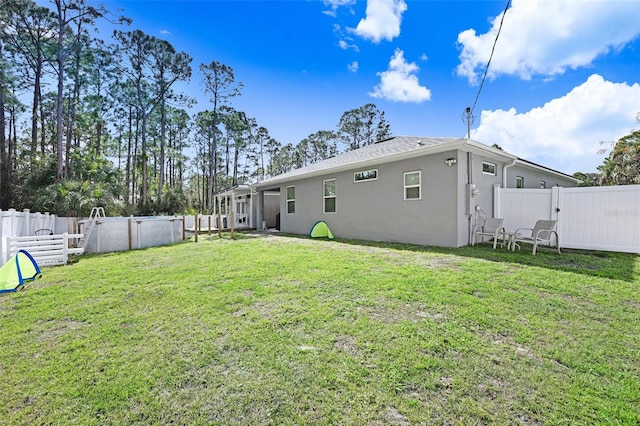 rear view of property featuring a fenced in pool and a lawn