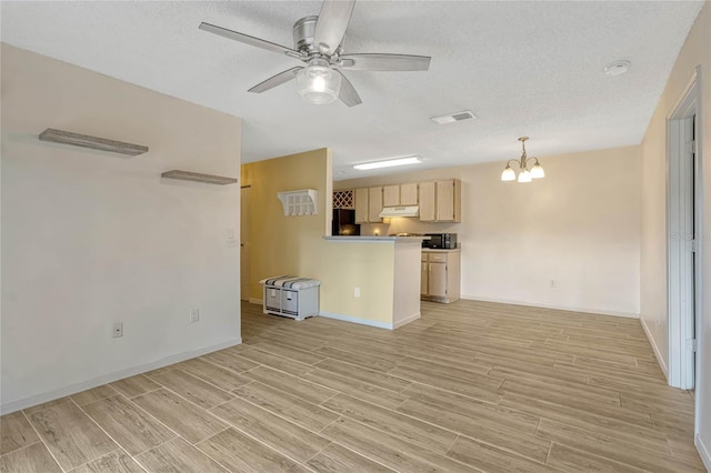 unfurnished living room with ceiling fan with notable chandelier and a textured ceiling