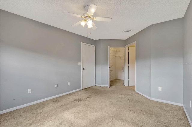 unfurnished room featuring ceiling fan, light carpet, and a textured ceiling