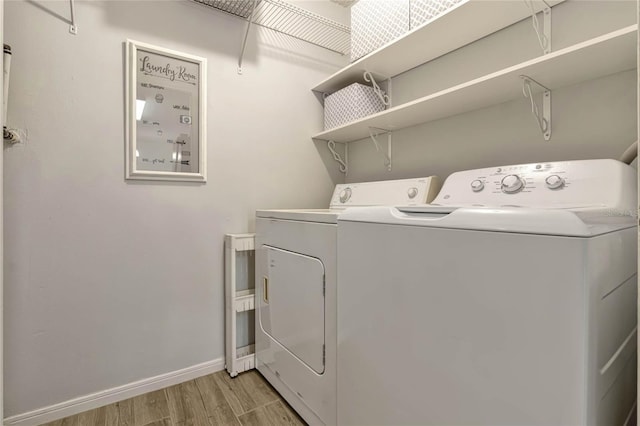 clothes washing area featuring washer and clothes dryer and light wood-type flooring