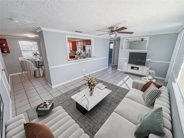 tiled living room featuring ceiling fan, ornamental molding, and a textured ceiling