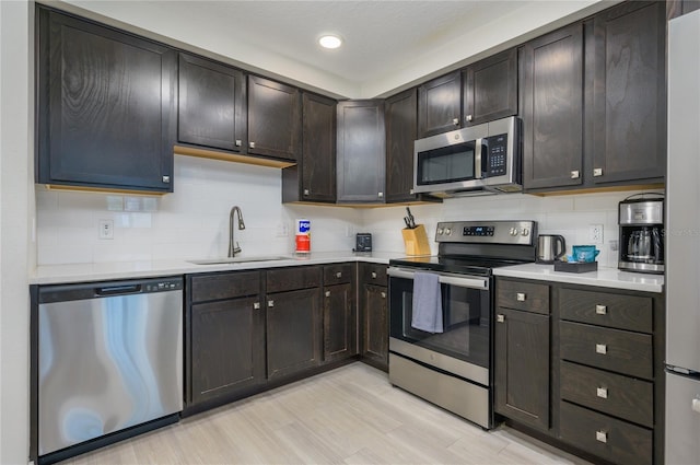 kitchen featuring dark brown cabinetry, stainless steel appliances, sink, and backsplash