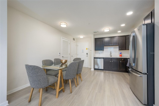 dining space featuring sink and light hardwood / wood-style flooring