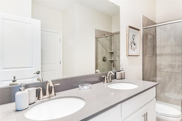 bathroom with a shower with door, vanity, and toilet