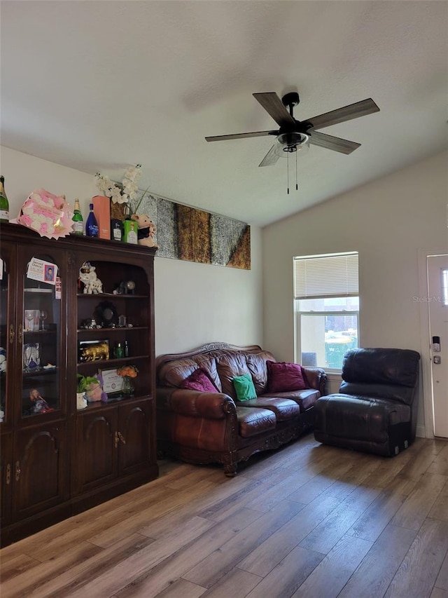 living room featuring hardwood / wood-style flooring, vaulted ceiling, and ceiling fan