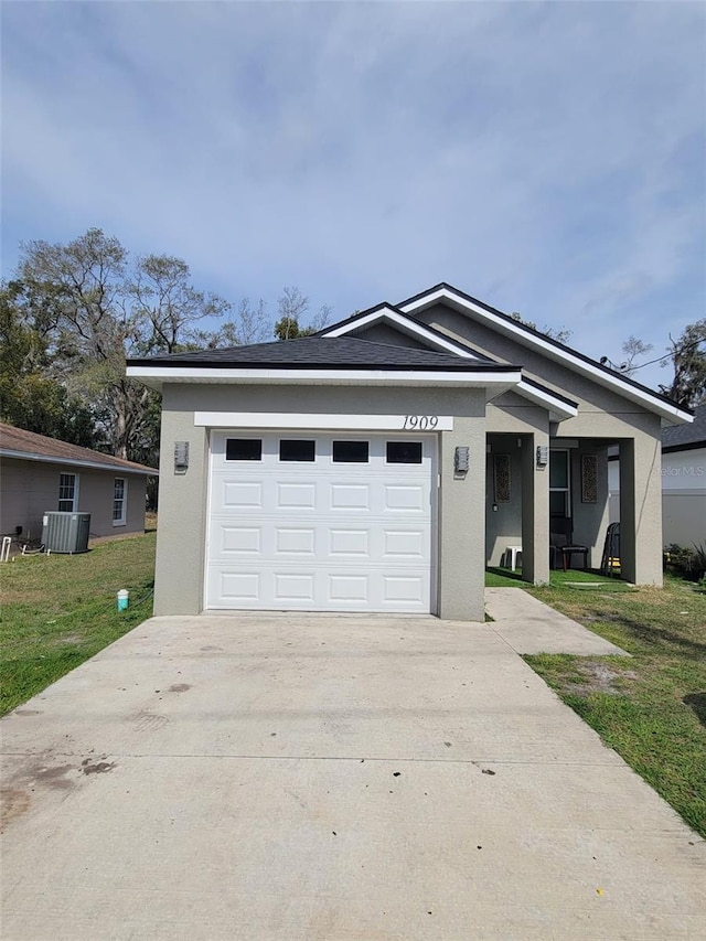 view of front of property featuring concrete driveway, central AC, a front yard, and stucco siding