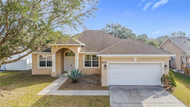 view of front of property featuring a front lawn and a garage