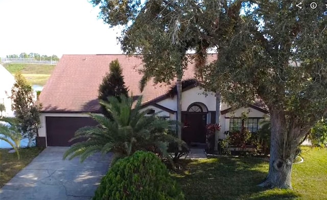 view of front of property with a garage and a front lawn