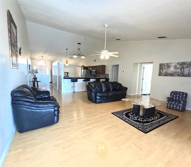 living room with lofted ceiling, light hardwood / wood-style floors, and ceiling fan