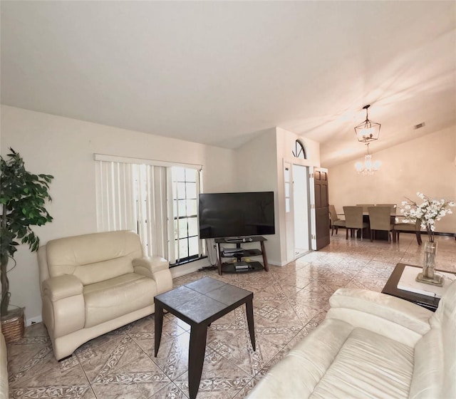 living room with a chandelier and vaulted ceiling