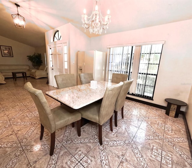 dining area featuring lofted ceiling and a notable chandelier