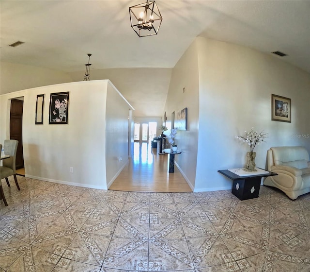 interior space with light tile patterned flooring, a chandelier, and vaulted ceiling