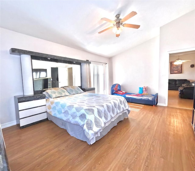 bedroom with hardwood / wood-style flooring, vaulted ceiling, and ceiling fan