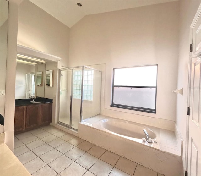 bathroom featuring independent shower and bath, vanity, lofted ceiling, and tile patterned floors