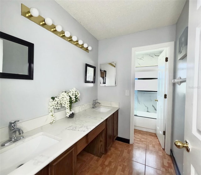 bathroom with vanity, tile patterned floors, a textured ceiling, and washtub / shower combination