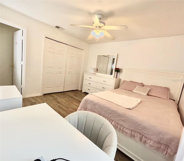 bedroom with dark wood-type flooring, ceiling fan, and a closet