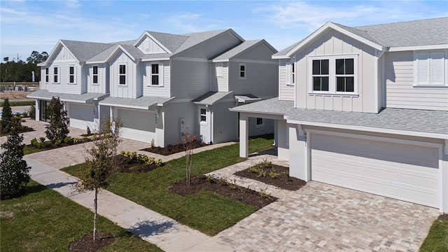 view of front of home featuring decorative driveway, a garage, board and batten siding, and a shingled roof