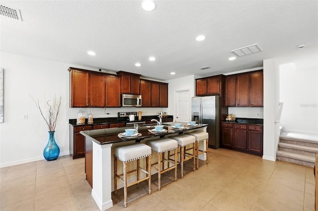 3270 Mt Vernon Way, Kissimmee, FL 34741 - kitchen with stainless steel appliances, visible vents, recessed lighting, a kitchen bar, and dark countertops