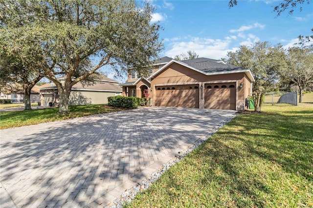 view of front facade featuring decorative driveway, stucco siding, an attached garage, fence, and a front lawn