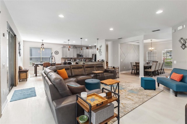 living area with a chandelier, recessed lighting, visible vents, and baseboards