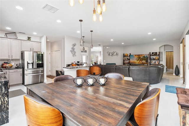 dining space featuring arched walkways, visible vents, and recessed lighting