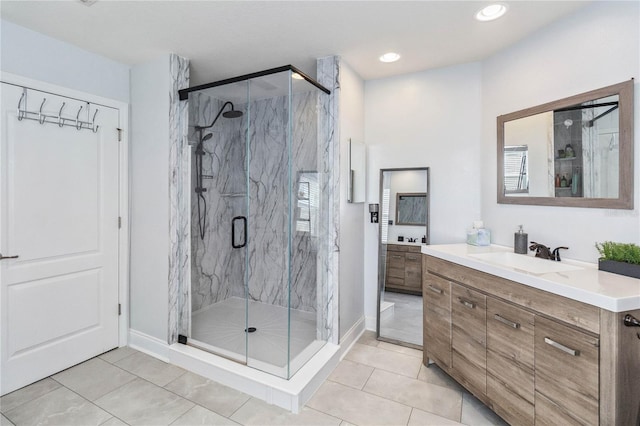 bathroom with recessed lighting, vanity, a marble finish shower, and tile patterned floors