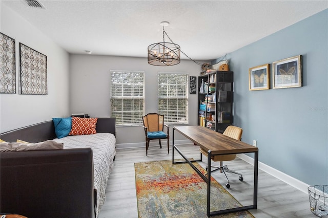 office featuring a textured ceiling, wood finished floors, visible vents, and baseboards