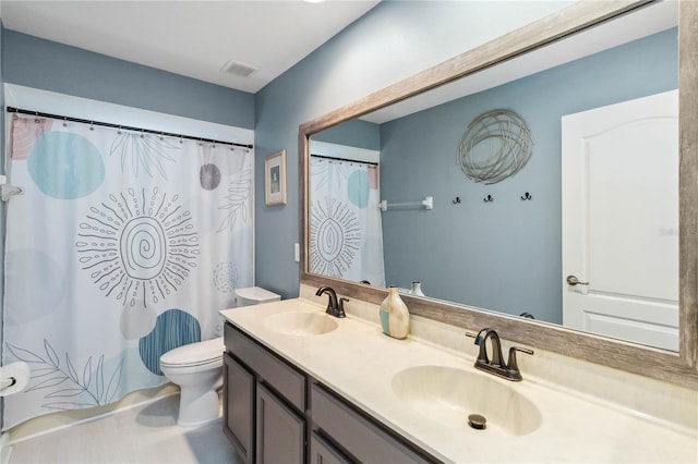 full bath with visible vents, a sink, toilet, and double vanity