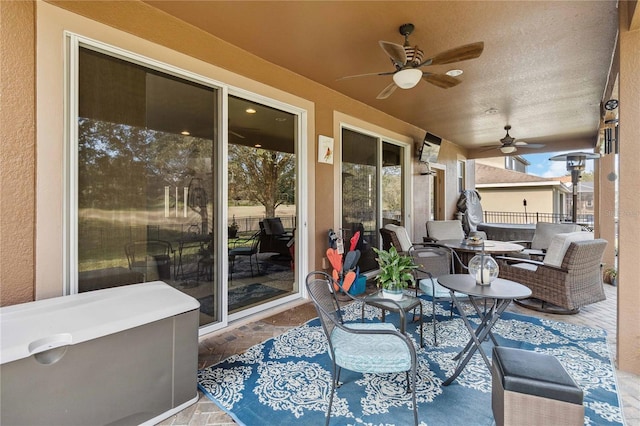 view of patio with ceiling fan, outdoor dining area, and fence