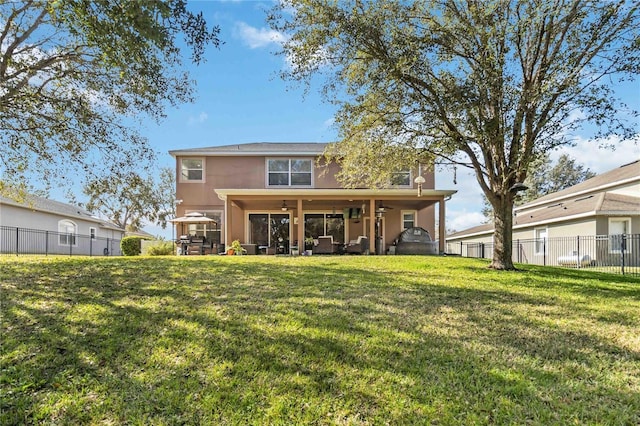 back of property featuring a yard, a fenced backyard, and stucco siding