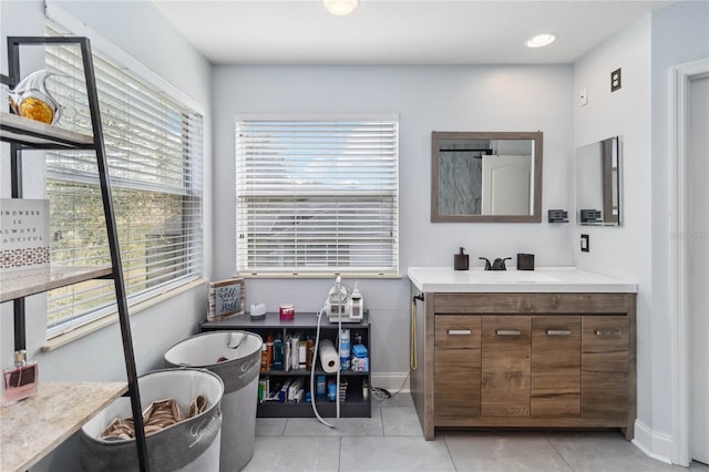 bathroom featuring tile patterned flooring, vanity, and baseboards