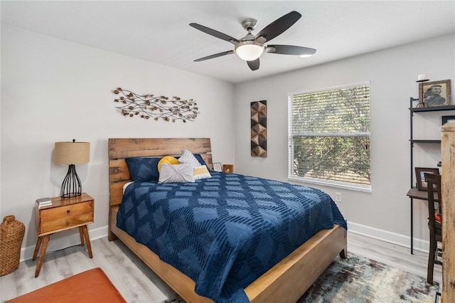 bedroom featuring light wood-type flooring, a ceiling fan, and baseboards