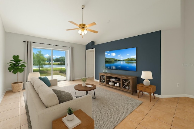 living area with baseboards, ceiling fan, light tile patterned flooring, and vaulted ceiling