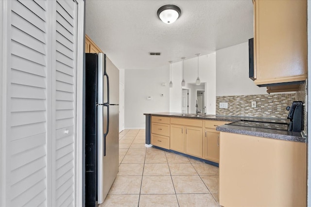 3304 Kelsey Ln, Saint Cloud, FL 34772 - kitchen featuring freestanding refrigerator, dark countertops, a peninsula, light tile patterned floors, and a textured ceiling
