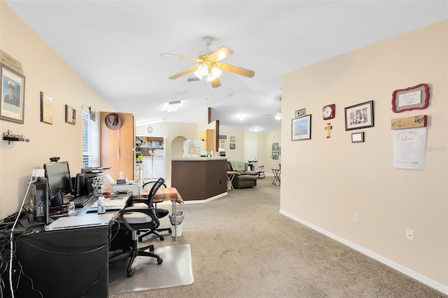 carpeted office space with vaulted ceiling and ceiling fan