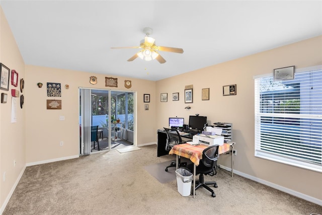 carpeted office space featuring ceiling fan