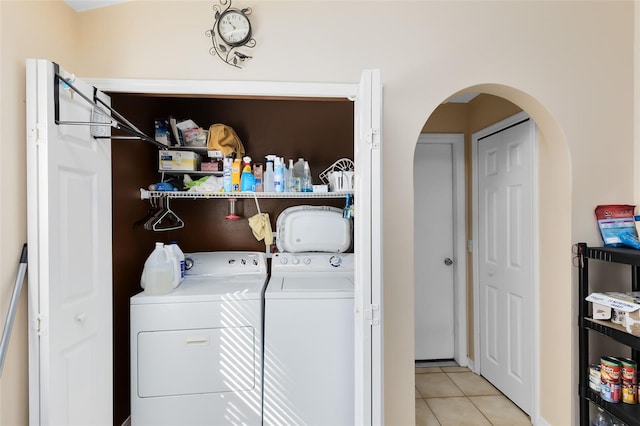 clothes washing area featuring light tile patterned flooring and washer and clothes dryer