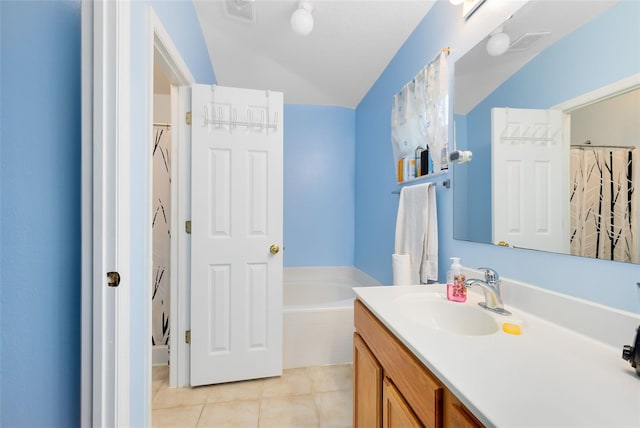 bathroom with tile patterned flooring, vanity, and a relaxing tiled tub