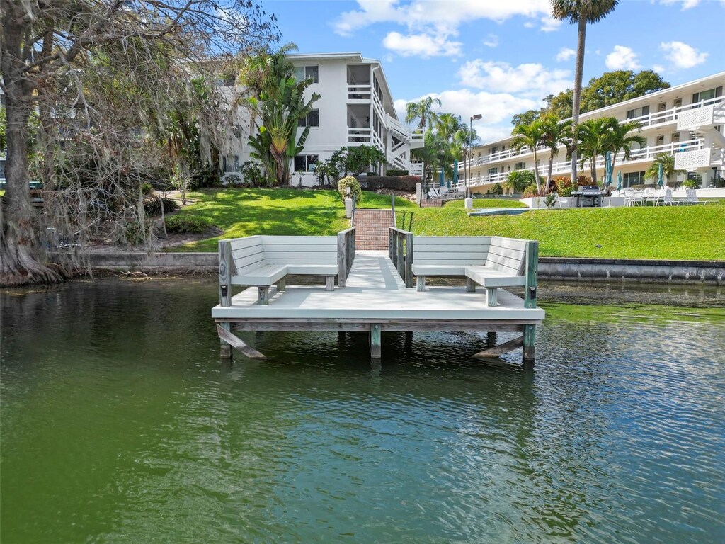 dock area with a lawn and a water view
