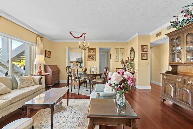 living room with a textured ceiling, ornamental molding, dark hardwood / wood-style floors, and a chandelier