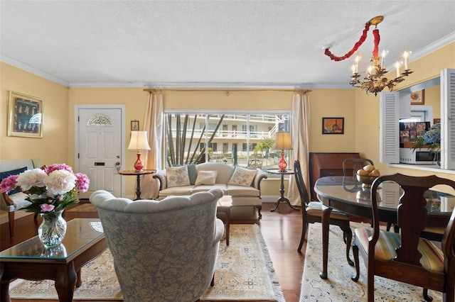 living room featuring crown molding, hardwood / wood-style floors, a notable chandelier, and a textured ceiling