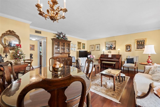 dining room with dark hardwood / wood-style flooring, ornamental molding, and an inviting chandelier