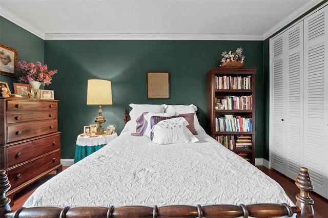 bedroom with hardwood / wood-style flooring, ornamental molding, and a closet