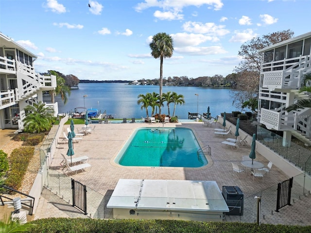 view of pool with a patio area and a water view