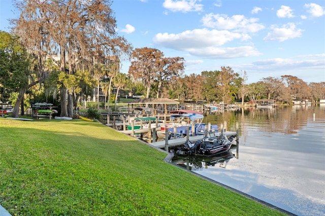 view of dock with a water view and a yard