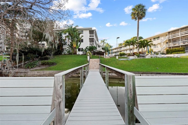 dock area with a water view and a yard