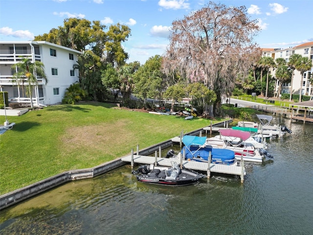 view of dock with a water view and a yard