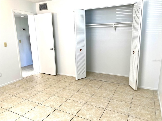 unfurnished bedroom with a closet and light tile patterned floors