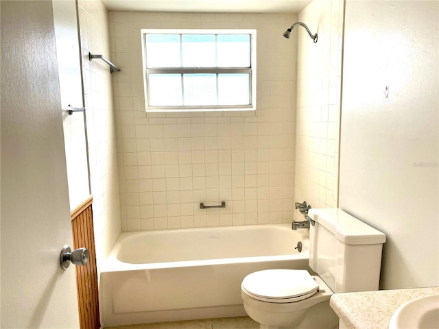 full bathroom featuring tiled shower / bath, vanity, and toilet