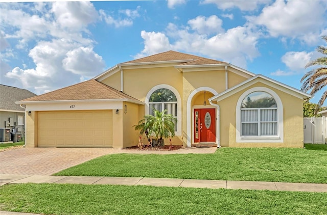 view of front of property with cooling unit, a garage, and a front lawn